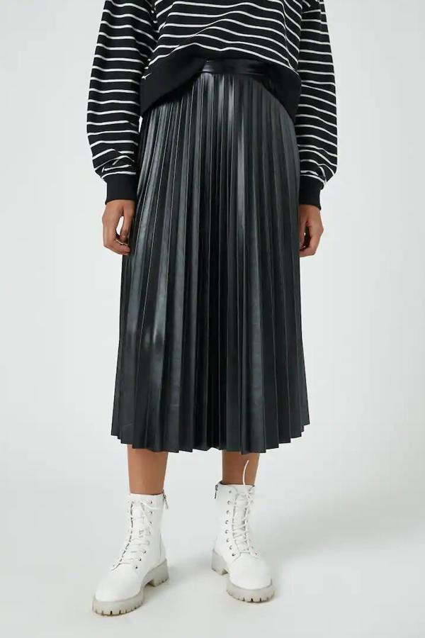 En color negro en tejido efecto piel, esta falda plisada es de Pull & Bear y tiene un precio de 22,99 euros.