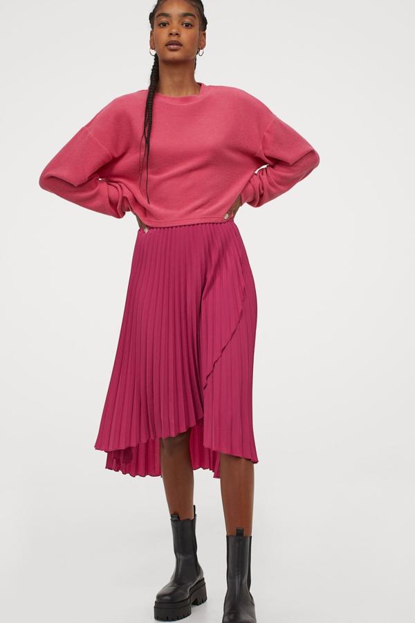 Con frente cruzado cosido, esta falda plisada en color rosa oscuro cuenta con elástico revestido en la cintura y tiene un precio de 24,99 euros. Es de H&M.