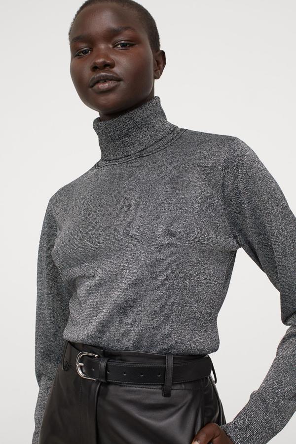 Este jersey de cuello alto de H&M confeccionado en punto fino es de color negro y está confeccionado con hilos metalizados brillantes en la trama. Con puños y bajo en punto de canalé, cuesta 24,99 euros y está disponible entre las tallas XS y L.