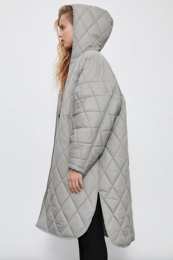 Confeccionado en tejido water repelent, este abrigo acolchado con capucha de Zara en color piedra viene con manga larga acabada en puño elástico interior y bajo con aberturas laterales. Cuesta 49,95 euros y está disponible entre las tallas XS y XL.