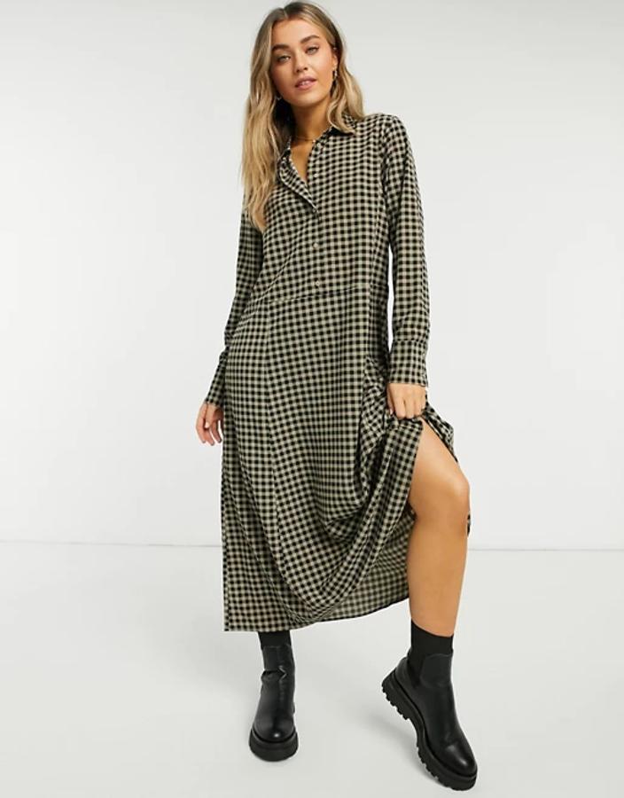 Estampado de cuadros Vichy para este vestido en caqui y negro con cuello italiano, mangas largas con puños abotonados y diseño holgado. Es de Monki y podemos encontrarlo en Asos por 47,99 euros en las tallas XS, S y M.