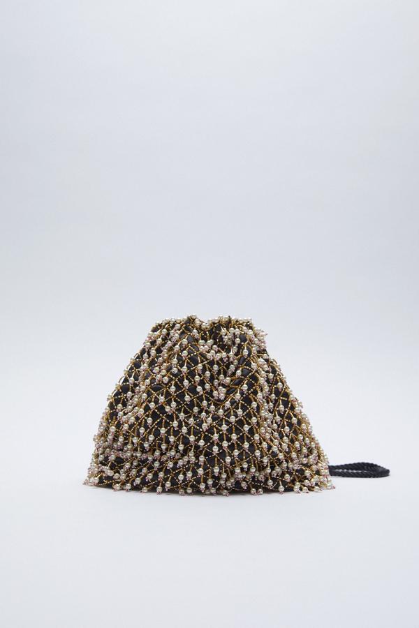 Bolso de fiesta de color negro cubiero con perlas blancas y pedrería dorada de Zara (39,99 euros). Una nueva versión del clásico bolso de mano