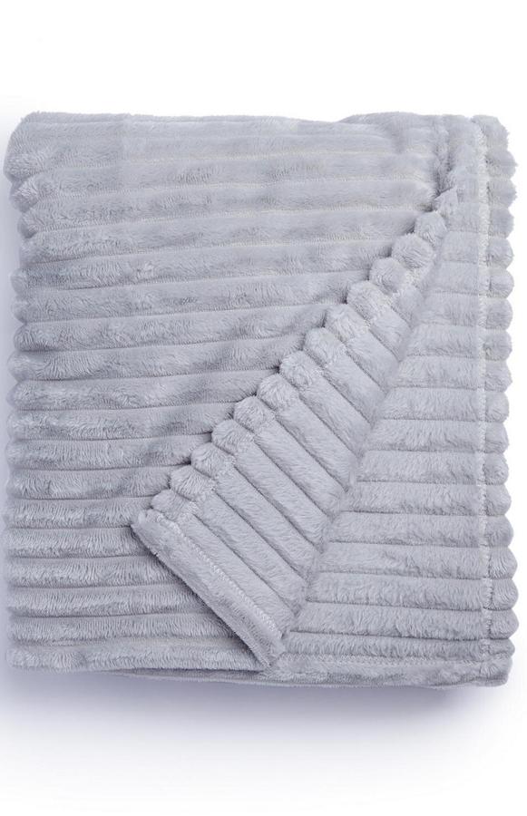 En color gris, aunque disponible en otros tonos, esta suave manta con medias de 120x150 centímetros tiene un precio de 6 euros.