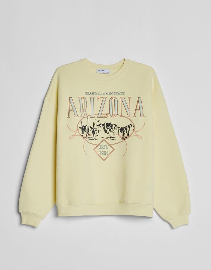 Sudadera amarilla con motivos grises, de Bershka (19,99 euros).