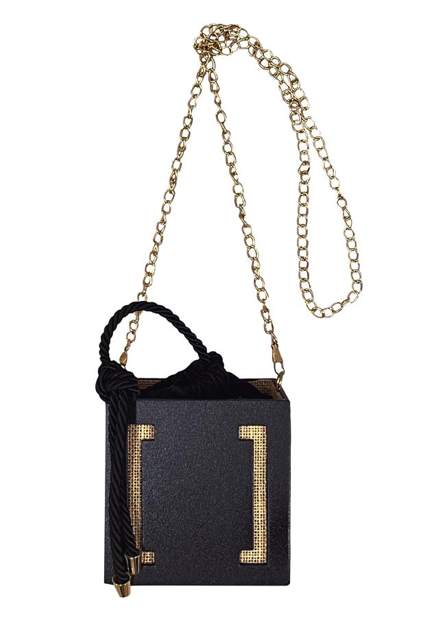 Este bolso es de madera lacada, está hecho a mano, lleva el interior en arpillera, una cadena dorada y una limosnera en crepe con cordón de seda. Una maravilla de Candelas y Felipa (200 euros), una firma de moda de Cuidad Real creada por Maite Bustamante y Guillermo Román, madre e hijo.