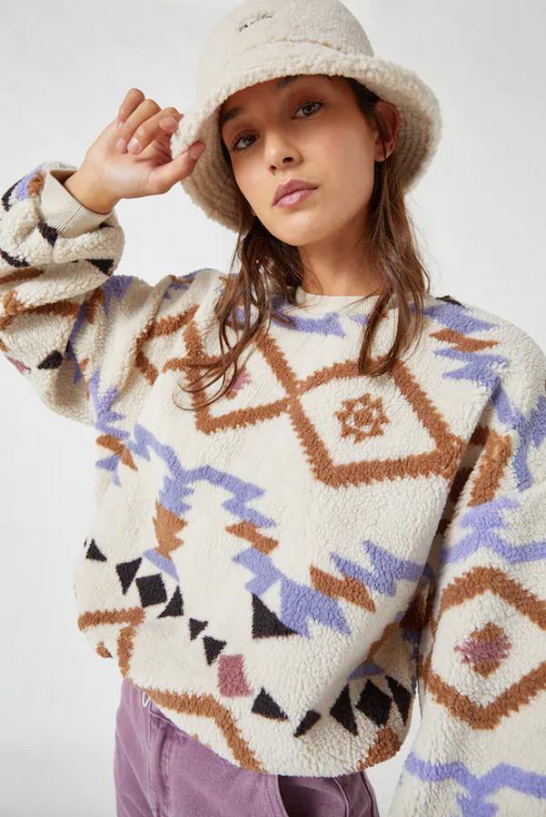 En blanco con motivos geométricos en tonos marrones y azules, esta sudadera en borreguito de Pull&Bear cuesta 22,99 euros y está disponible entre las tallas XS y XL.