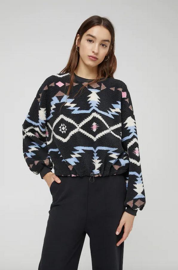 Con estampado de motivos invernales en tonos azules y blancos sobre fondo negro, esta sudadera en borreguito de Pull&Bear está disponible entre las tallas XS y XL y tiene un precio de 22,99 euros.