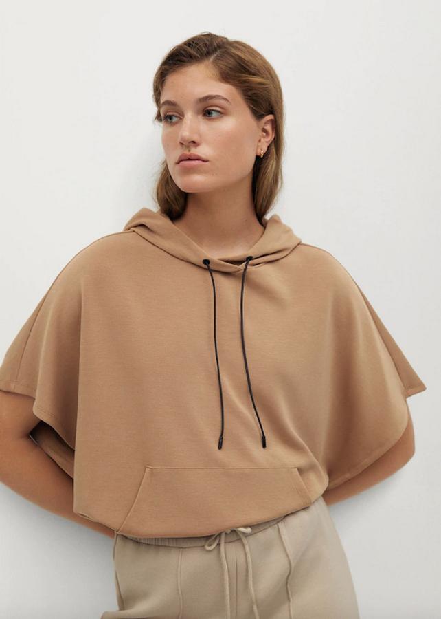 Disponible en beige o en negro, esta sudadera de Mango de diseño ancho y capucha con cordón ajustable viene con cintura elástica y está confeccionada en mezcla de modal. Podemos encontrarla en las tallas S, M y L por 29,99 euros.