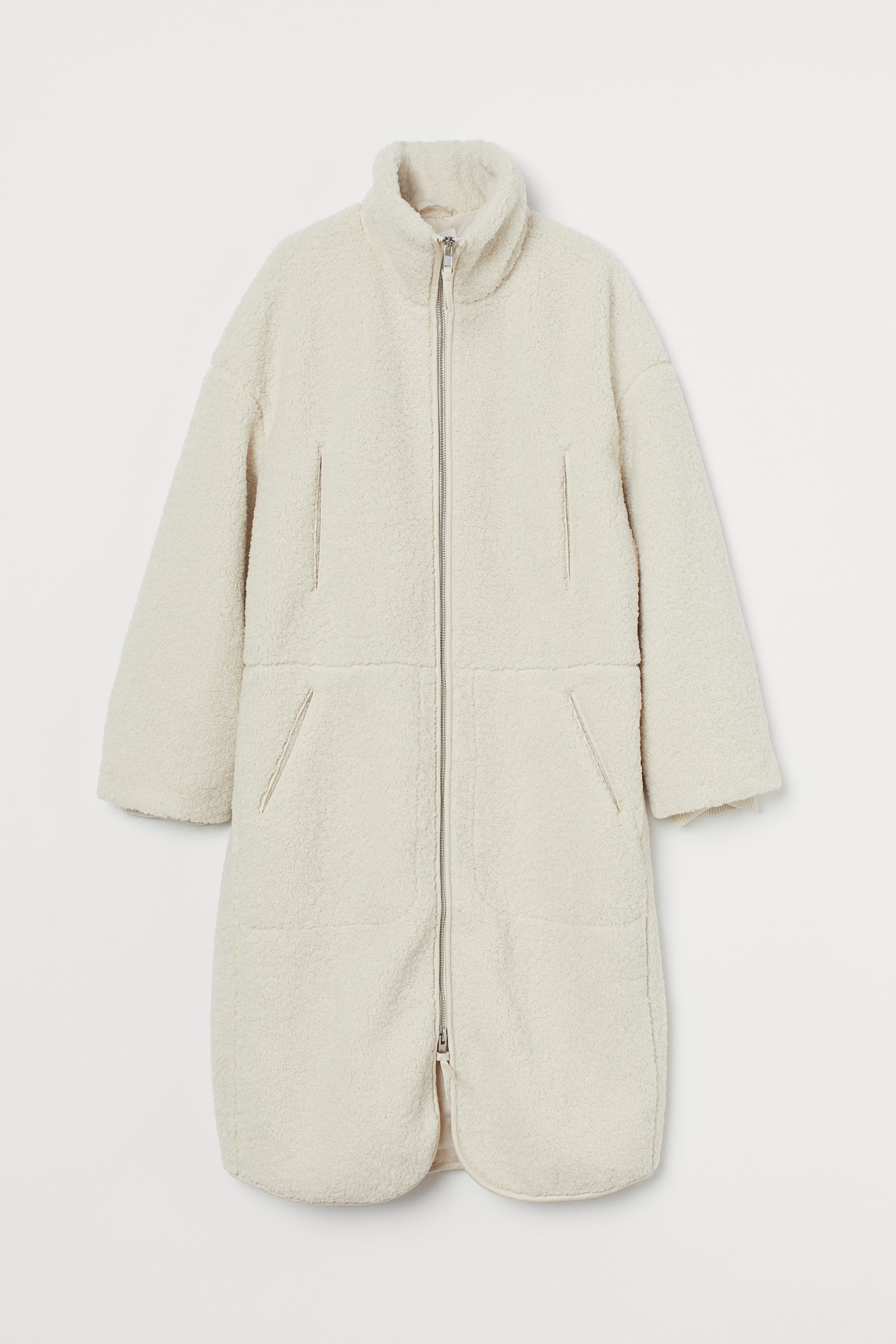 Abrigo oversize hasta la rodilla, de borreguito suave con cierre de cremallera y bolsillos delanteros. De H&M. (59,99 euros).