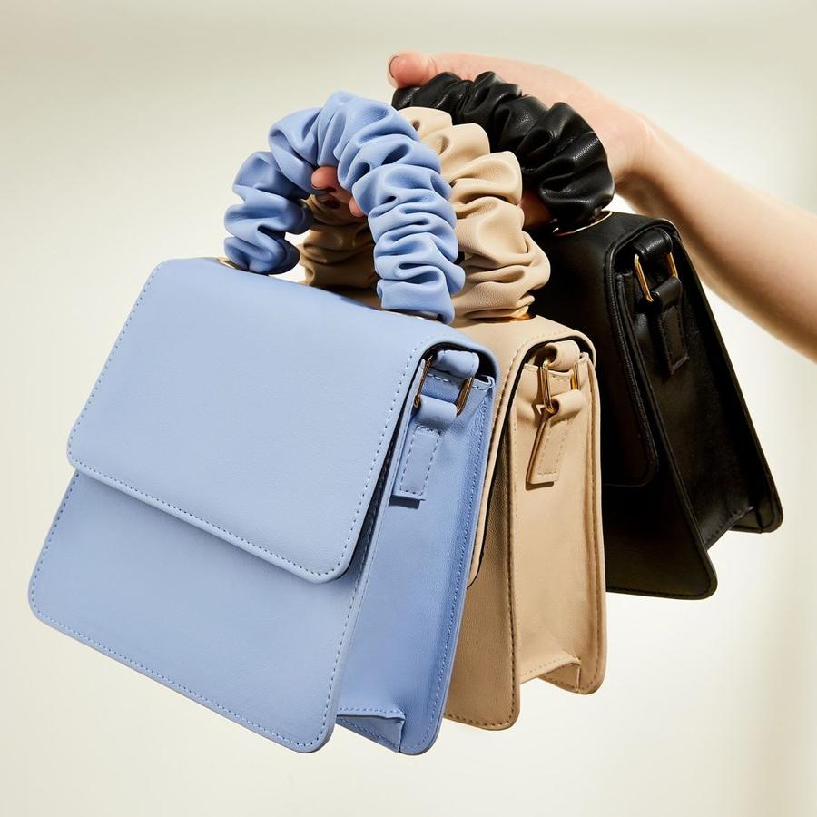 Bolsos de mano efecto piel en azul, cámel o negro, con detalle de asa corta y rizada (8 euros en Primark).