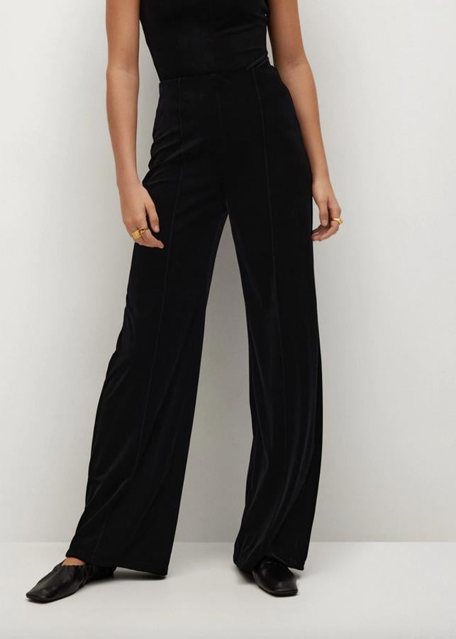 Diseño palazzo para este pantalón negro de terciopelo con tiro alto y cintura elástica que podemos encontrar en Mango por 29,99 euros entre las tallas XS y L.