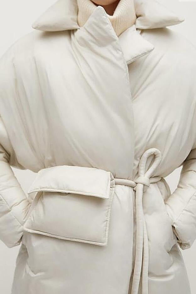 El pequeño bolso, está unido al abrigo gracias a un fino cinturón del mismo tejido.