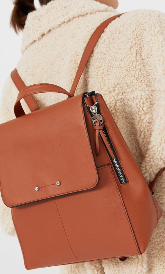 Esta mochila con detalle de cremalleras en los laterales está disponible en camel o negro y tiene un precio de 15,99 euros