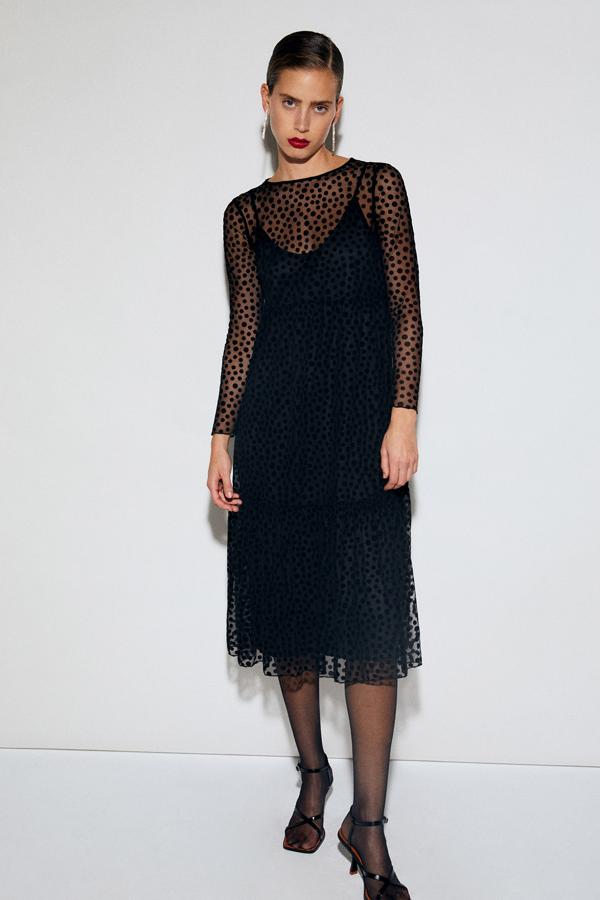 En color negro, este vestido midi de manga larga con detalle de plumeti tiene un precio de 29,99 euros.