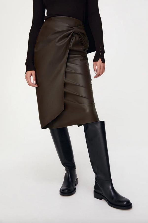 Diseño de tubo para esta falda midi de Zara en efecto piel y color marrón topo con detalle delantero cruzado con lazo y cierre de cremallera. Podemos encontrarla entre las tallas XS y XL por 29,95 euros.