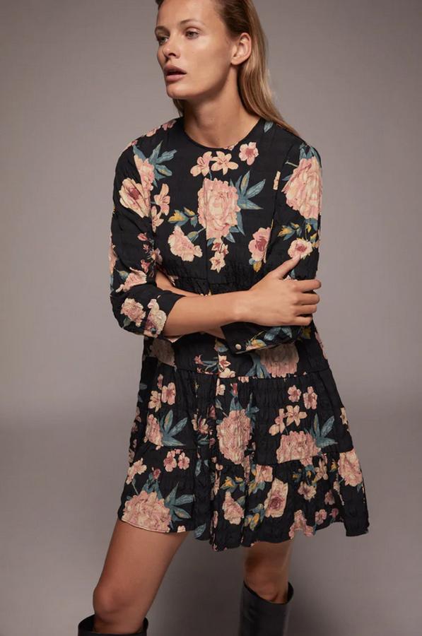Estampado de flores en tonos pastel para este vestido mini de fondo negro con cuello redondo, manga corta por debajo del codo y bajo acabado en volante. Es de Zara, esstá rebajado y de 29,95 euros ha pasado a costar 17,99 euros, aunque solo podemos encontrarlo en la talla L.