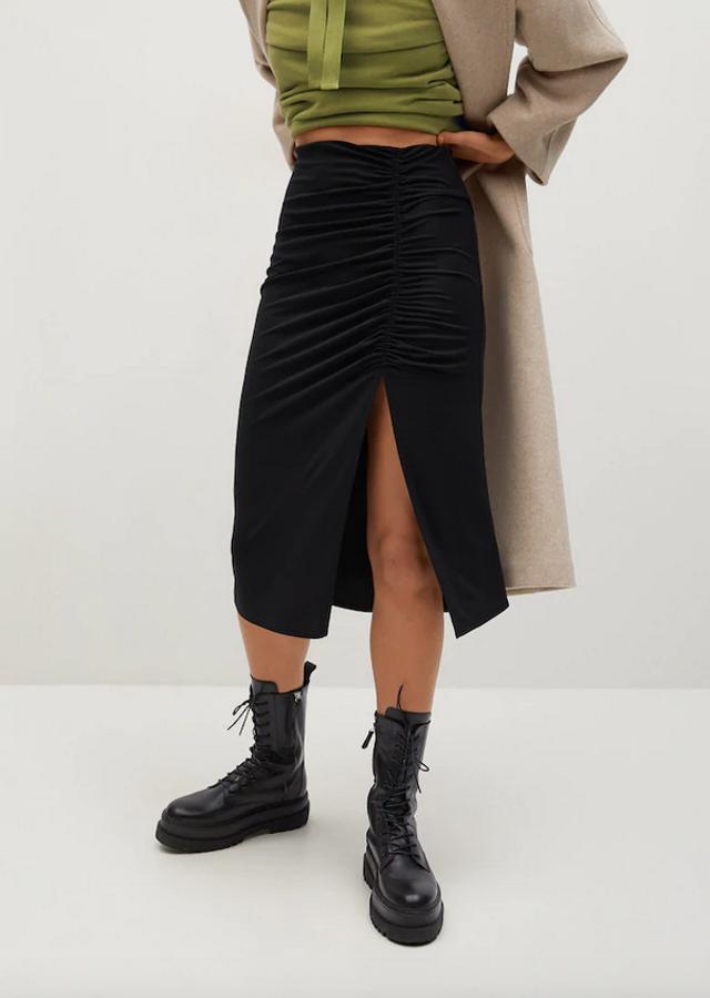 Diseño midi de tubo con drapeado y abertura lateral para esta falda negra de Mango que podemos encontrar en las tallas S, M y L por 19,99 euros.