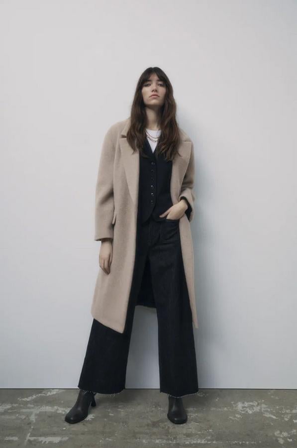 En gris topo, confeccionado en mezcla de lana, con cuello de solapa y mangas largas con hombro caído, este abrigo de Zara viene con bolsillos de solapa en delantero y de vivo en el pecho. Con forro interior, podemos encontrarlo entre las tallas XS y XL por 109 euros.