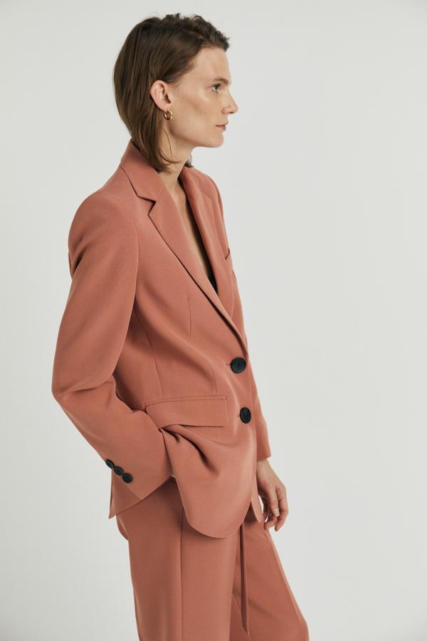 Blazer de traje en color salmón con botones negros. Rebajada de 39,99 a 25,99 euros.