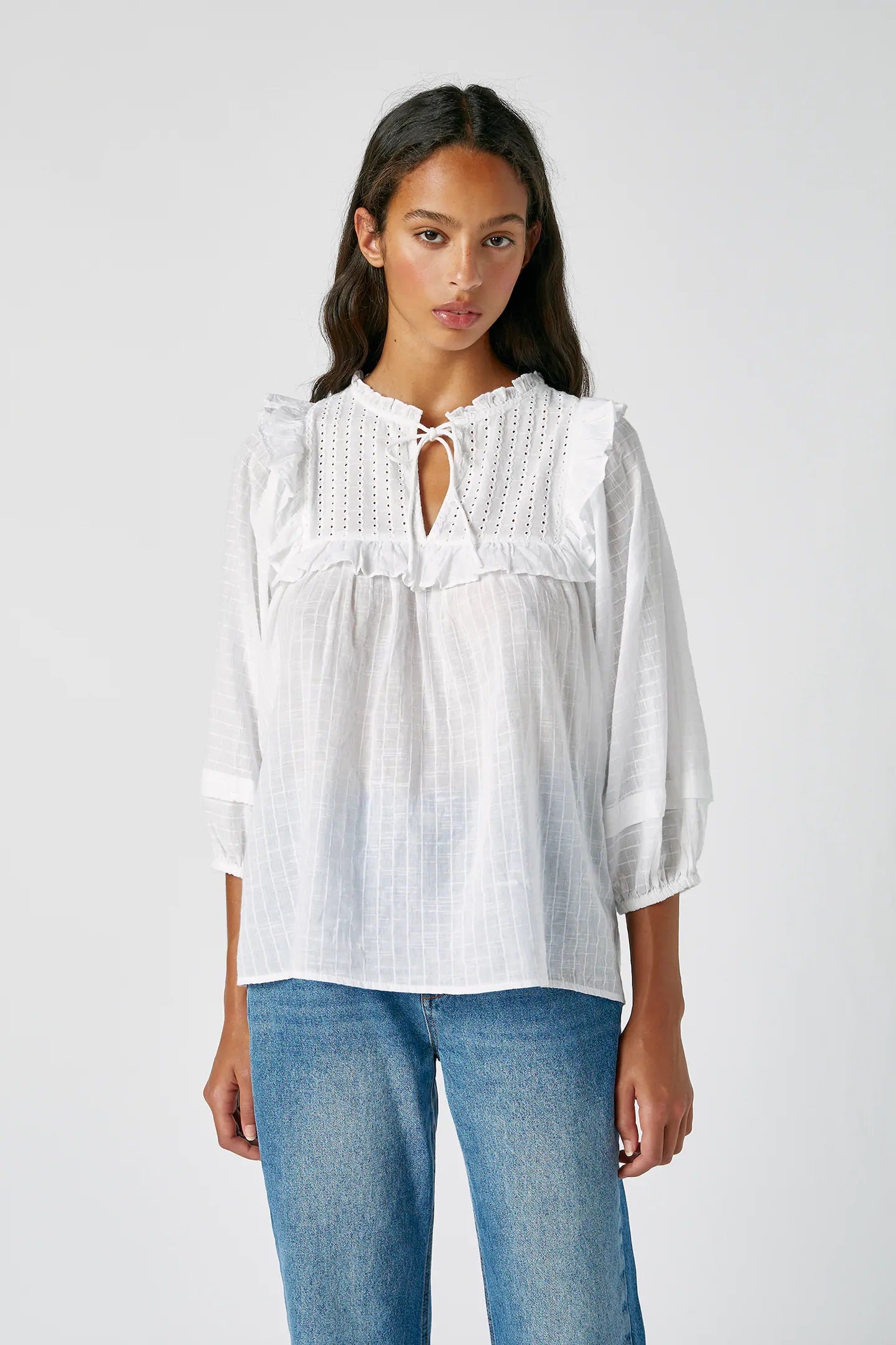 Blusa blanca con lazada y volantes. Aplica un 43% a sus 22,99 euros y añádela a tu cesta de favoritos.