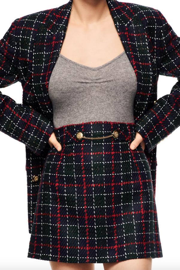 A juego con la blazer, esta falda corta de tiro alto en color negro con cuadros rojos y blancos viene con detalle de falsos botones y cadena metálica en delantero. Tiene un precio de 29,95 euros y está disponible entre las tallas XS y XXL.