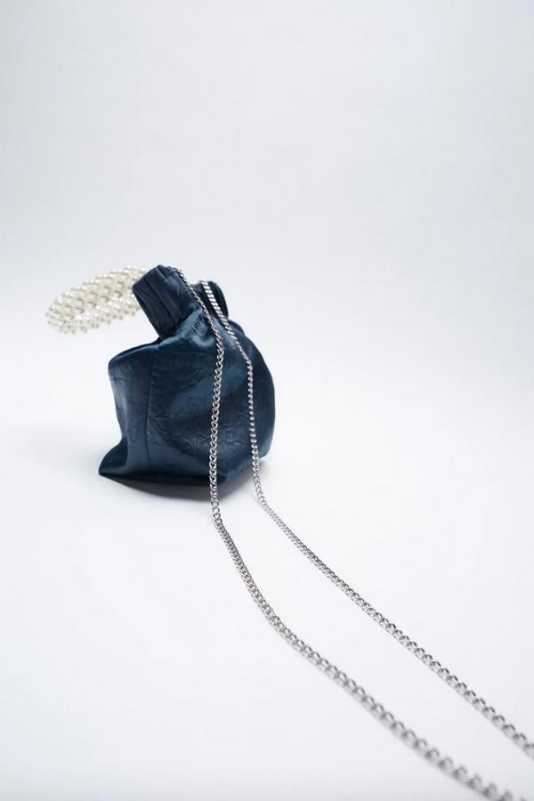 Formato bandolera en color azul con cuerpo en efecto arrugado y asa de mano con perlas para este bolso de Zara que también tiene asa de hombro con cadena en función bandolera. Con cierre mediante imán, ha pasado de 22,95 euros a 15,99 euros.