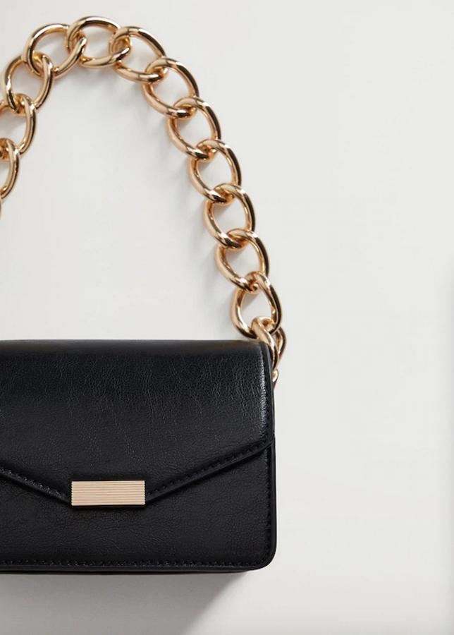 En formato pequeño, color negro y cierre metálico de imán en dorado, este bolso de mano de Mango con asa de maxicadena dorada costaba 29,99 euros y ahora podemos comprarlo por 15,99 euros.