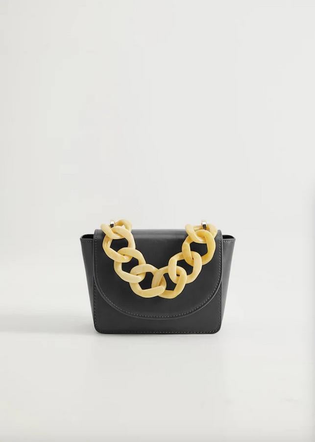 Con asa corta de maxicadena en marfil y asa de hombro a tono, este bolso mini de Mango con cierre metálico de imán y solapa frontal con clip oculto costaba 19,99 euros y ahora podemos comprarlo por 9,99 euros.