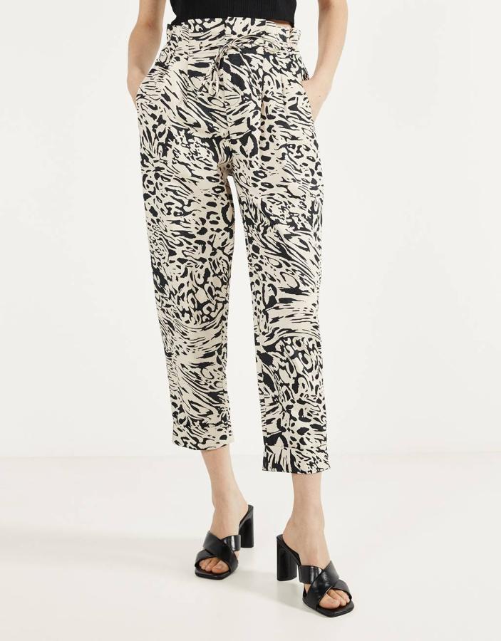 Estampado de leopardo en negro y crudo para este pantalón con cintura paperbag de Bershka con bajos por encima del tobillo y bolsillos laterales. De 19,99 euros ha pasado a costar 12,99 euros y está disponible entre las tallas 32 y 42.