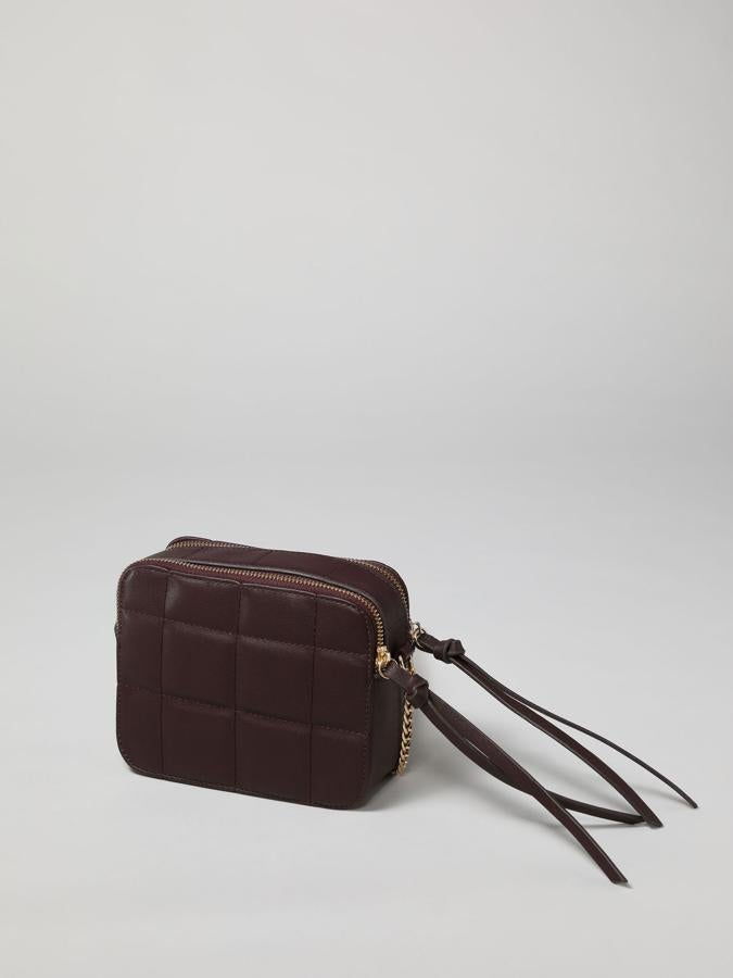 Formato rectangular y diseño acolchado para este bolso en color burdeos con asa de hombro de cadena dorada, el mismo tono de las dos cremalleras superiores. Costaba 9,9 euros y ahora podemos comprarlo por 5,99 euros.