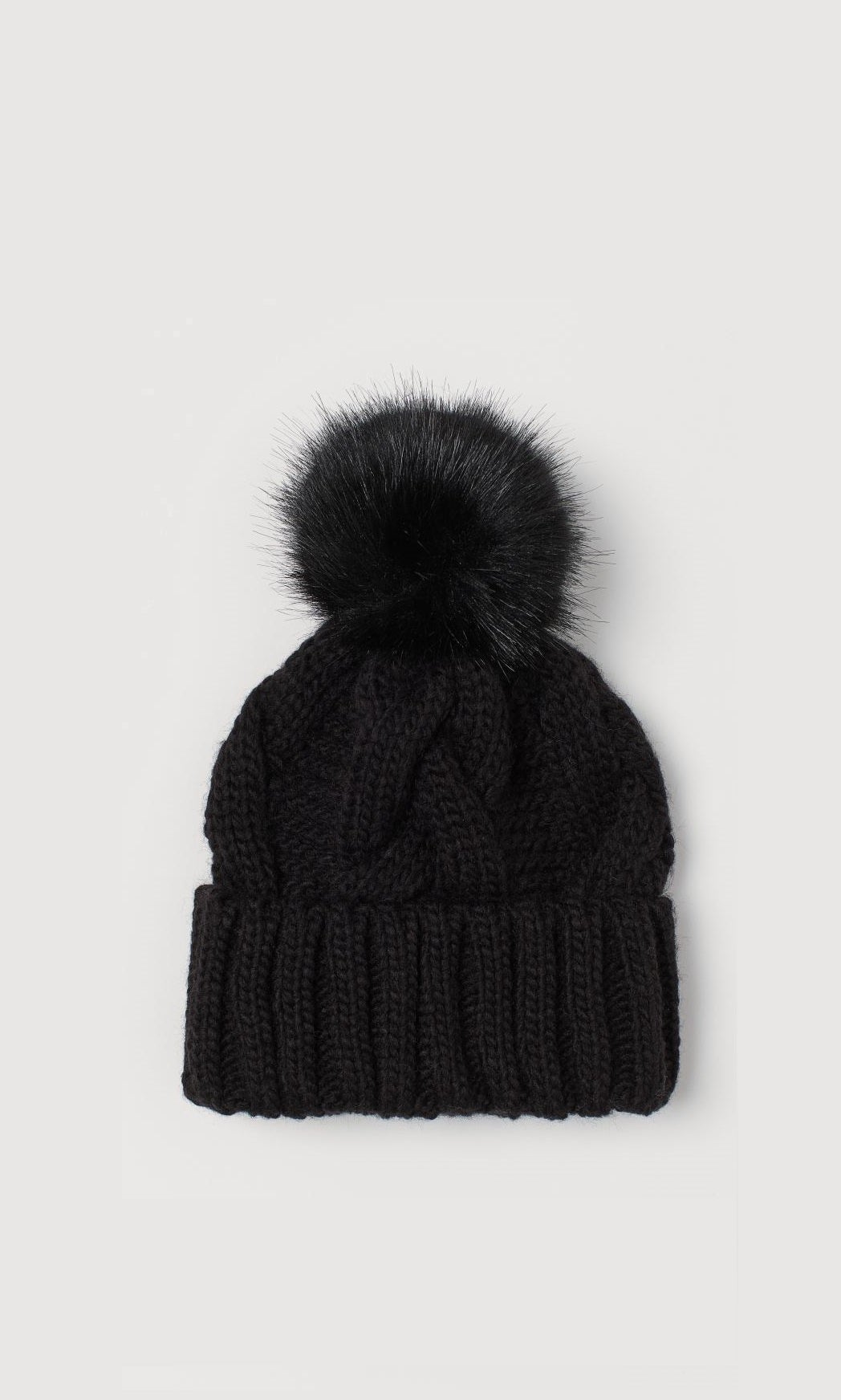 Gorro de punto grueso con pompón en color negro de H&M. (9,99 euros).