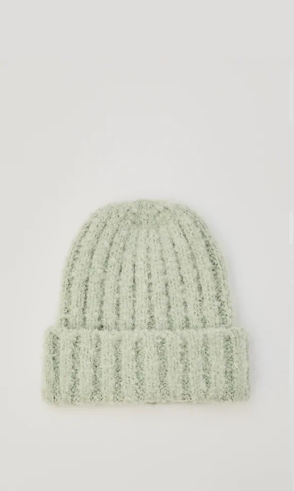 En color verde agua, gorro de tipo beanie de punto. Uno de los gorros más bonitos del low cost que hemos encontrado en Pull&Bear. (12,99 euros).