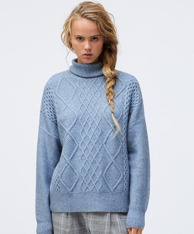 Disponible en azul o en gris, este calentito jersey de punto con cuello alto tiene un precio rebajado de 25,99 euros.