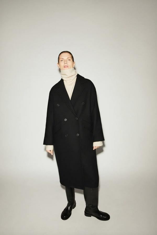 Confeccionado con tejido en mezcla de lana, este abrigo oversize de Zara con cuello solapa y cierre frontal cruzado con botones en color negro viene con bolsillos con solapa laterales y forro interior. Tiene un precio de 99,95 euros y está disponible entre las tallas XS y XL.
