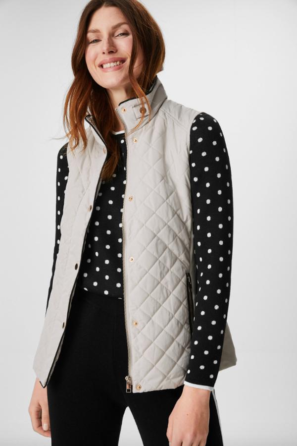 Con cuello mao, aplicaciones elásticas en los laterales y cierre frontal de cremallera y botones oculto con tapeta, este chaleco con bolsillos laterales de C&A en color crema tiene un precio de 29,99 euros y está disponible entre las tallas 36 y 50 y en color negro.