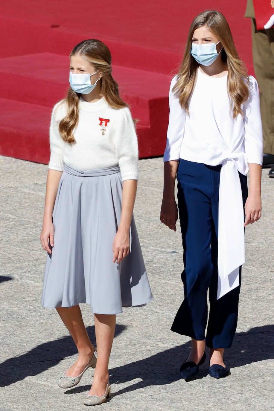 La hija mayor de los reyes Felipe y Letizia, y su hermana Sofía, se convirtieron en las protagonistas del día. Leonor decidía apostar por una falda con vuelo y jersey blanco donde llevaba el Toisón de Oro. Sofía llevaba un conjunto de pantalón azul y camisa blanca con un gran lazo.