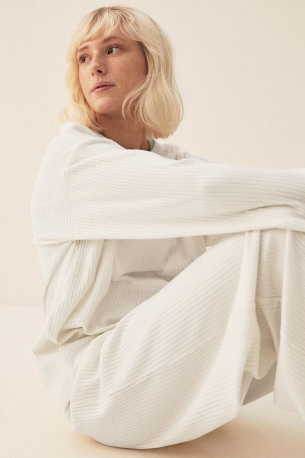 En blanco natural o beige jaspeado, este top en punto de canalé suave con cuello redondo, hombros caídos y mangas largas cuesta 19,99 euros y está disponible entre las tallas XS y XXL.