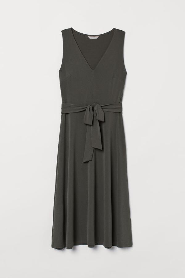 En verde caqui oscuro, confeccionado en punto de crepé con caída, este vestido de H&M con escote de pico, costura en la cintura con cinturón de anudar extraíble y falda amplia de corte evasé, tiene un precio de 24,99 euros, y está disponible entre las tallas XS y XL.