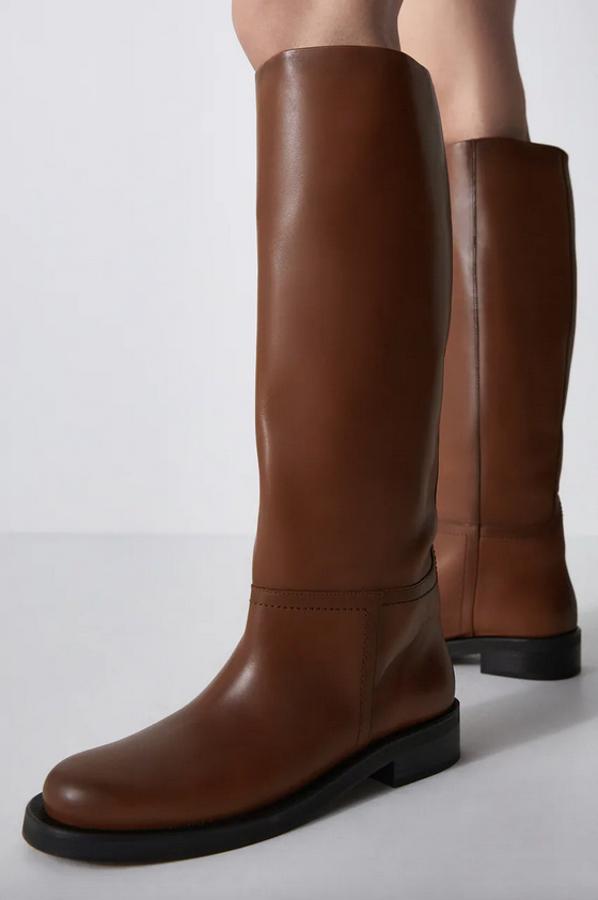 Con corte de piel y acabadas en punta redonda, estas botas de Zara en color marrón con tiradores interiores cuestan 119 euros y están disponibles entre los números 35 y 42.