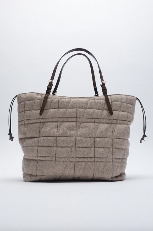 Este bolso de Zara en formato shopper con cuerpo con detalle de pespuntes, asas de hombro ajustables y cierre mediante fruncido está rebajado y de 35,95 euros ha pasado a costar 17,99 euros.