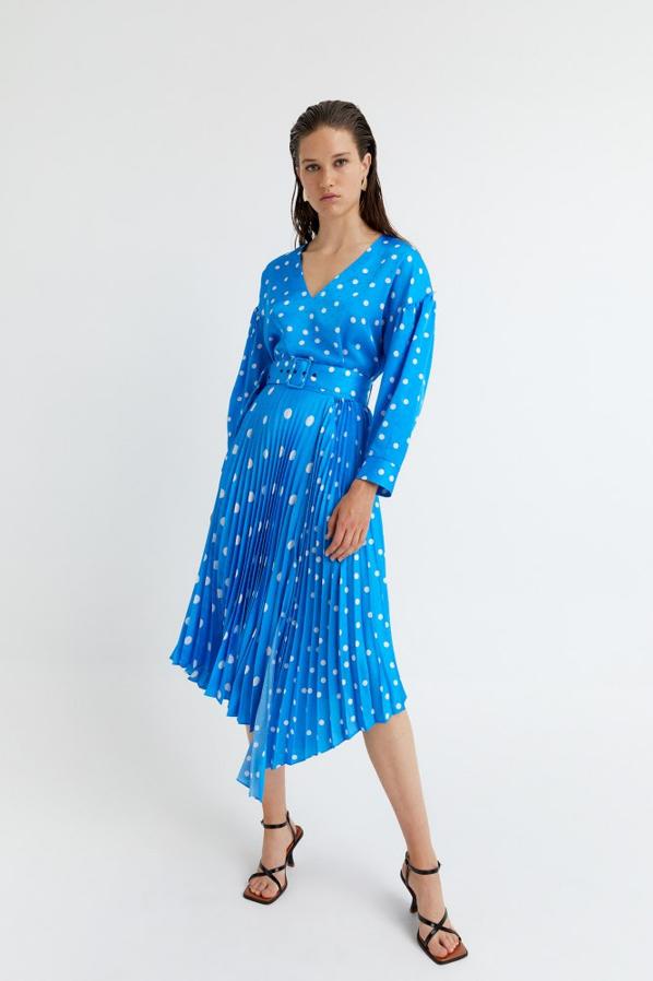 En color azul, con diseño midi de bajo asimétrico, estampado de lunares blancos y cinturón forrado a tono, esta falda plisada de Sfera tiene un precio de 39,99 euros y está disponible en las tallas S, M y L.