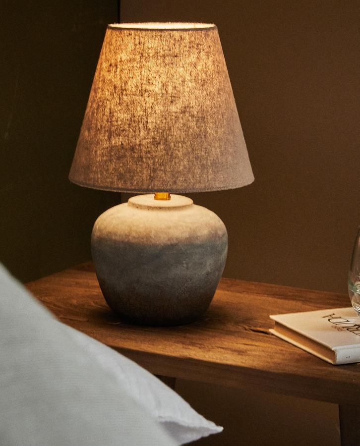 De tamaño mediano y con base de cemento, esta lámpara de mesa con tulipa en lino de color natural tiene un precio de 39,99 euros.