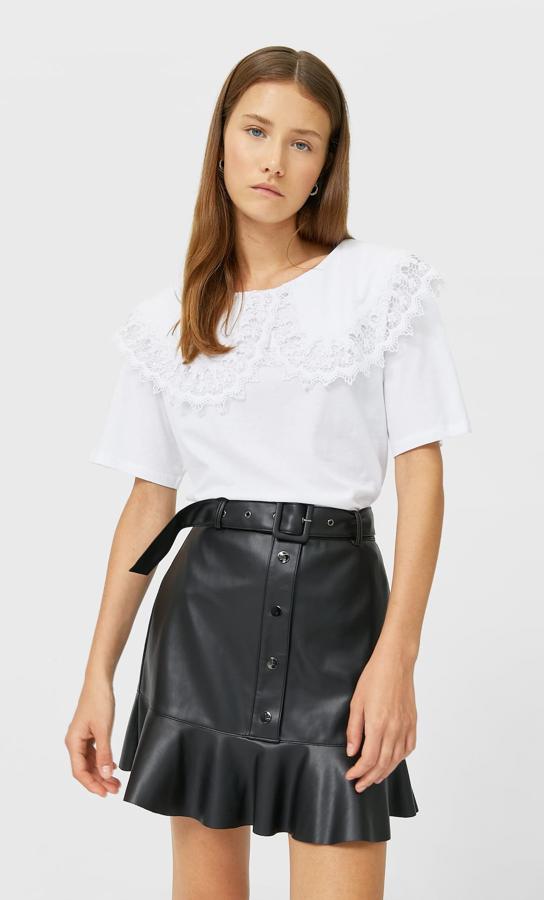 Minifalda negra de efecto puel con volante, botones y cinturón. Rebajada de 19,99 a 9,99 euros.