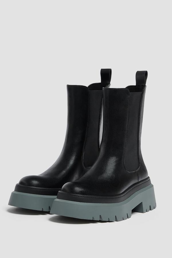 Botines negros tipo Chelsea con suela track de Pull and Bear: 45,99 euros. Botines planos con elásticos a los lados y suela track a contraste en gris. Del 35 al 41.