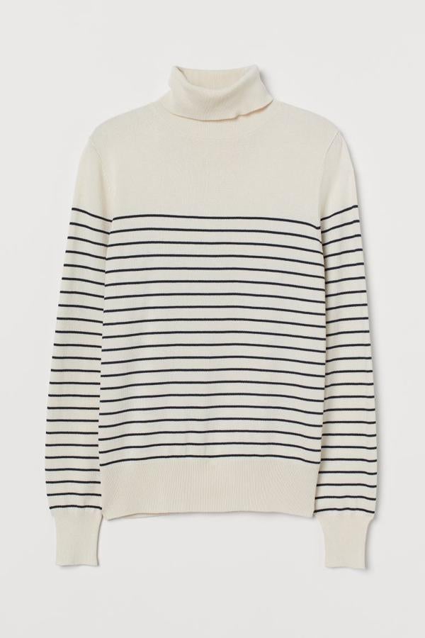 En color crema con estampado de rayas en azul marino, este jersey de H&M en punto fino suave con cuello alto de canalé y puños y bajos elásticos tiene un precio de 14,99 euros y está disponible entre las tallas XS y XXL.