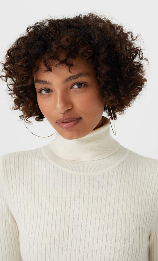 Disponible en vainilla, negro, beige y gris, este jersey de tacto suave con cuello alto y diseño trenzado ajustado está disponible en Stradivarius entre las tallas XS y XL por 15,99 euros.