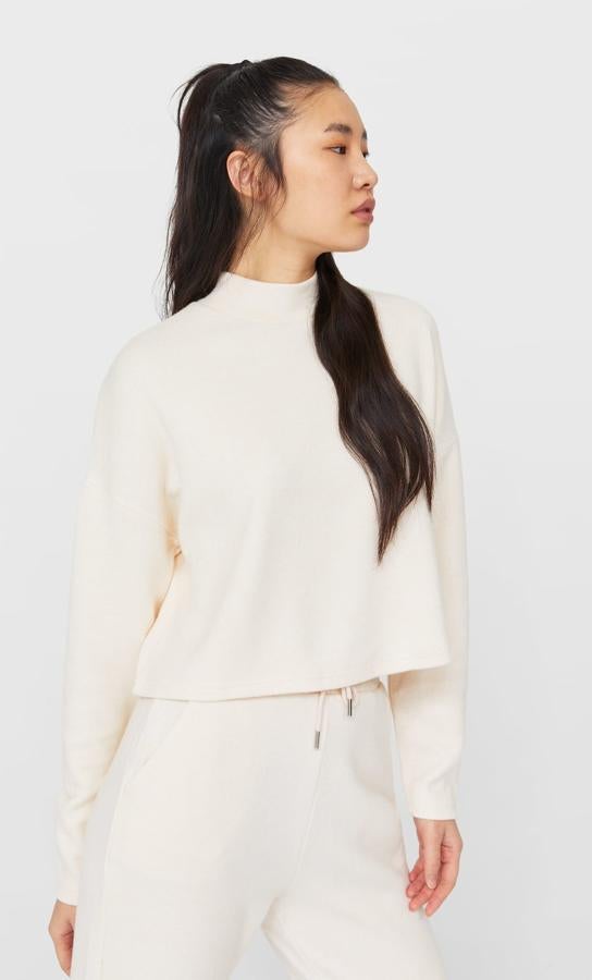 Diseño cropped con cuello subido y manga larga caída para este jersey de Stradivarius en color vainilla que también está disponible en otros tres colores y cuesta 15,99 euros. Podemos encontrarlo entre las tallas XS y XL.