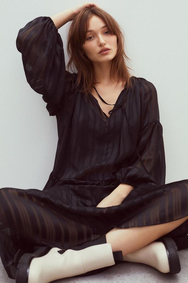 En gasa vaporosa, con cuello redondo fruncido, abertura con lazada en el escote y mangas globo largas de corte raglán, este vestido negro viene con costura fruncida en la cadera para dar amplitud. Podemos encontrarlo entre las tallas XS y XXL por 39,99 euros, aunque solo se vende en la web.