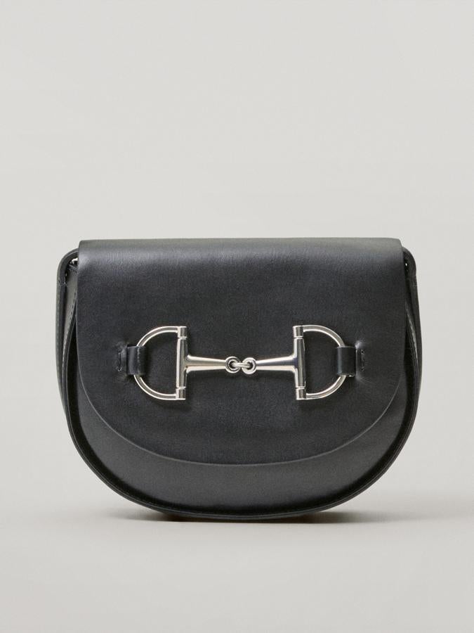 Disponible en negro y en color cuero, esta bandolera confeccionada en piel bovina con correa de hombro ajustable y cierre mediante solapa imantada con snap oculto tiene un estribo en la parte superior de la solapa. Costaba 99,99 euros y ahora podemos comprarla por 49,95 euros.