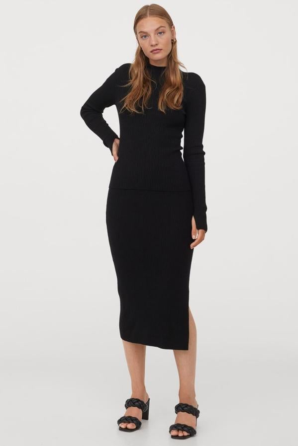 Disponible en negro y gris oscuro, esta falda entallada de H&M en punto de canalé con lana suave en la trama es de tiro alto, tiene cintura elástica revestida y abertura en un lateral. Cuesta 19,95 euros y solo queda en la talla Xs en negro y en XS, S y XXL en gris.